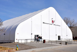 A large white fabric structure labeled "Maverick Pavilion" with people walking in front