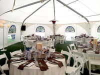 A white tent set up with decorated tables and chairs