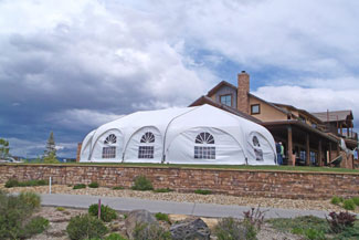A large white tent set up near a house
