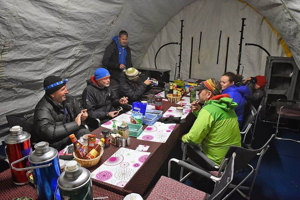 Mountaineers enjoy dinner in an Alaska Structures fabric shelter at a Mount Everest basecamp.