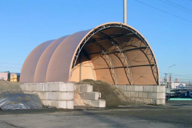 A multi-bay salt and sand storage building on concrete blocks for public works.
