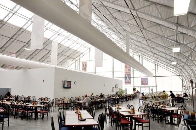 alaska-structures-college-dining-facility-and-bookstore-interior-1 Another interior view of the Mesa State College dining hall and bookstore highlights optional HVAC ducts and our skylight material near the peak, enhancing comfort and natural light within the pre-engineered fabric building from Alaska Structures®.