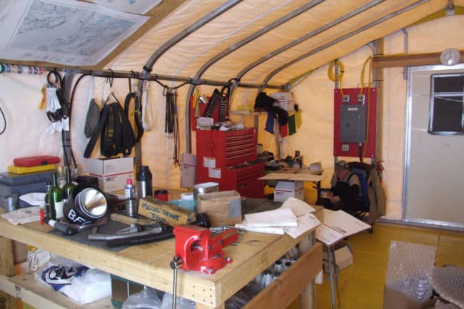 Alaska Structures GB fabric building mechanical workshop The interior of the mechanical workshop at a remote polar research camp features a GB Series™ fabric building from Alaska Structures®, providing a secure and organized space for essential equipment maintenance.