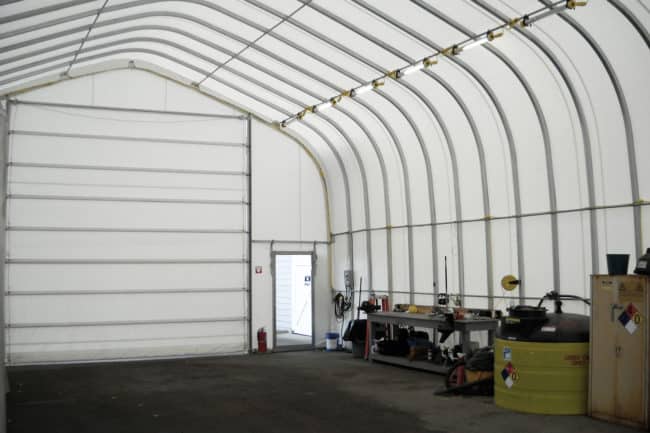 Alaska Structures GB fabric building mechanical workshop A raised 30' wide x 50' long HGB Series™ fabric building from Alaska Structures®, equipped with an optional fabric door, serves as a vehicle and equipment maintenance facility at a port in Washington state.