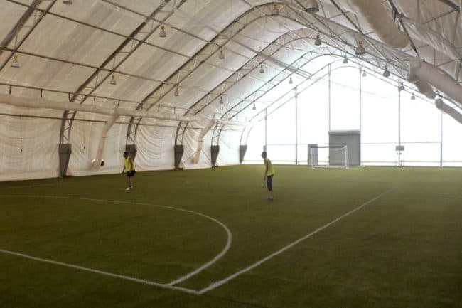 Alaska Structures indoor soccer field at mining camp An indoor soccer facility at a remote mining camp in West Africa utilizes a DAGB Series™ fabric building from Alaska Structures®, offering workers a large, temperature-controlled space for exercise and recreation.