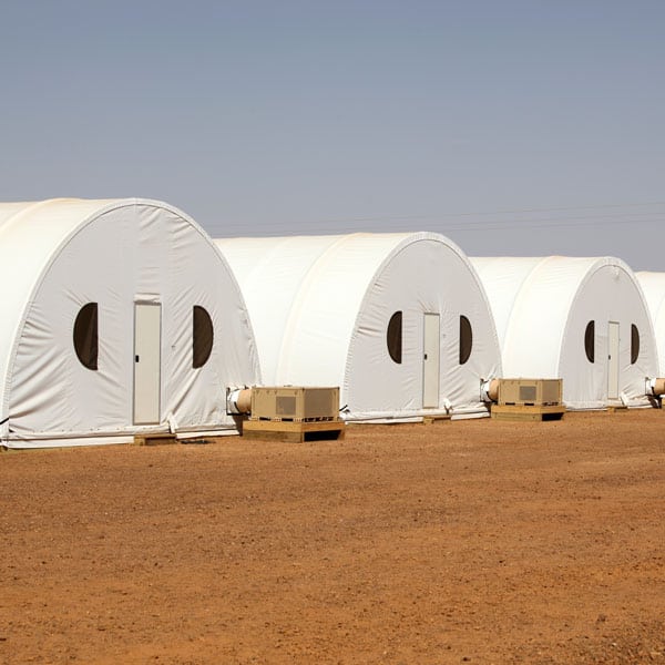 Fabric building with soft-wall partitions for private sleeping quarters.