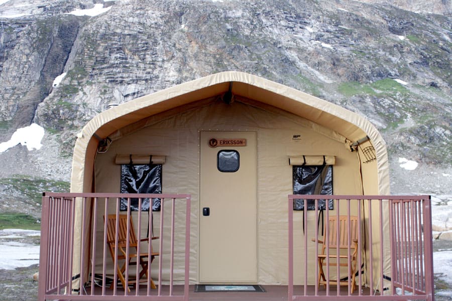 A front view of a TSX Series™ portable cabin, set up annually by Natural Habitat Adventures in Greenland, creates a luxury base camp for guests seeking a unique Arctic experience.