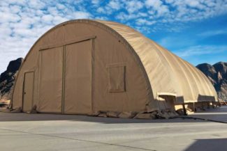 A large beige fabric tent set up in a mountainous area