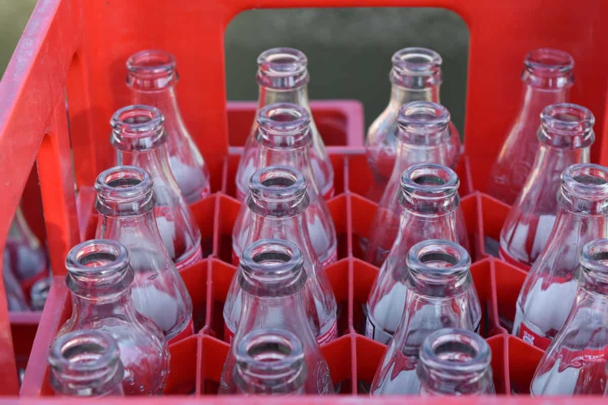 Glass bottles lined up in a red crate.