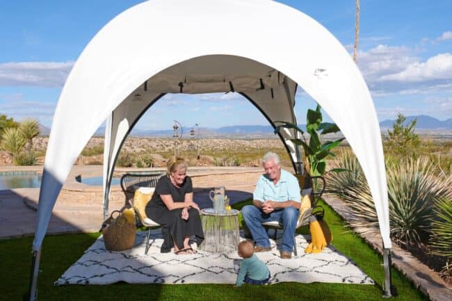 weatherport-canopy-10x10-poolside-cabana-1 A 10’ x 10’ WeatherPort® Canopy shown with a side curtain (rolled-up) provides a relaxing spot next to the family pool.