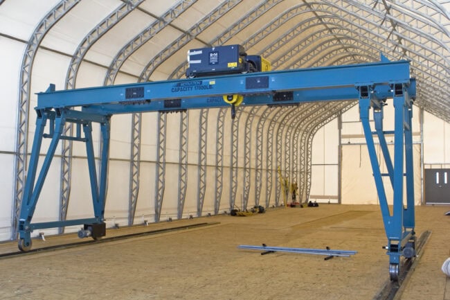 T3504x2336-19763-clean-rotate An onsite mechanical workshop, housed in a DAGB Series™ fabric building from Alaska Structures®, features a gantry crane that facilitates easy movement of heavy equipment within the facility