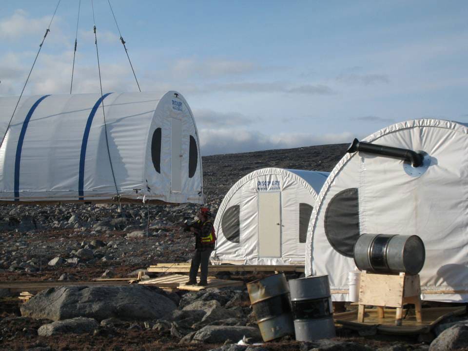 fly-in-camp-with-a-helicopter-sling-load-shelter-2 Helicopter sling-load installation of SQ Series™ fabric buildings for a fly-in camp in Iqaluit, Nunavut, demonstrating rapid deployment of lightweight, high-strength structures in remote Arctic conditions.