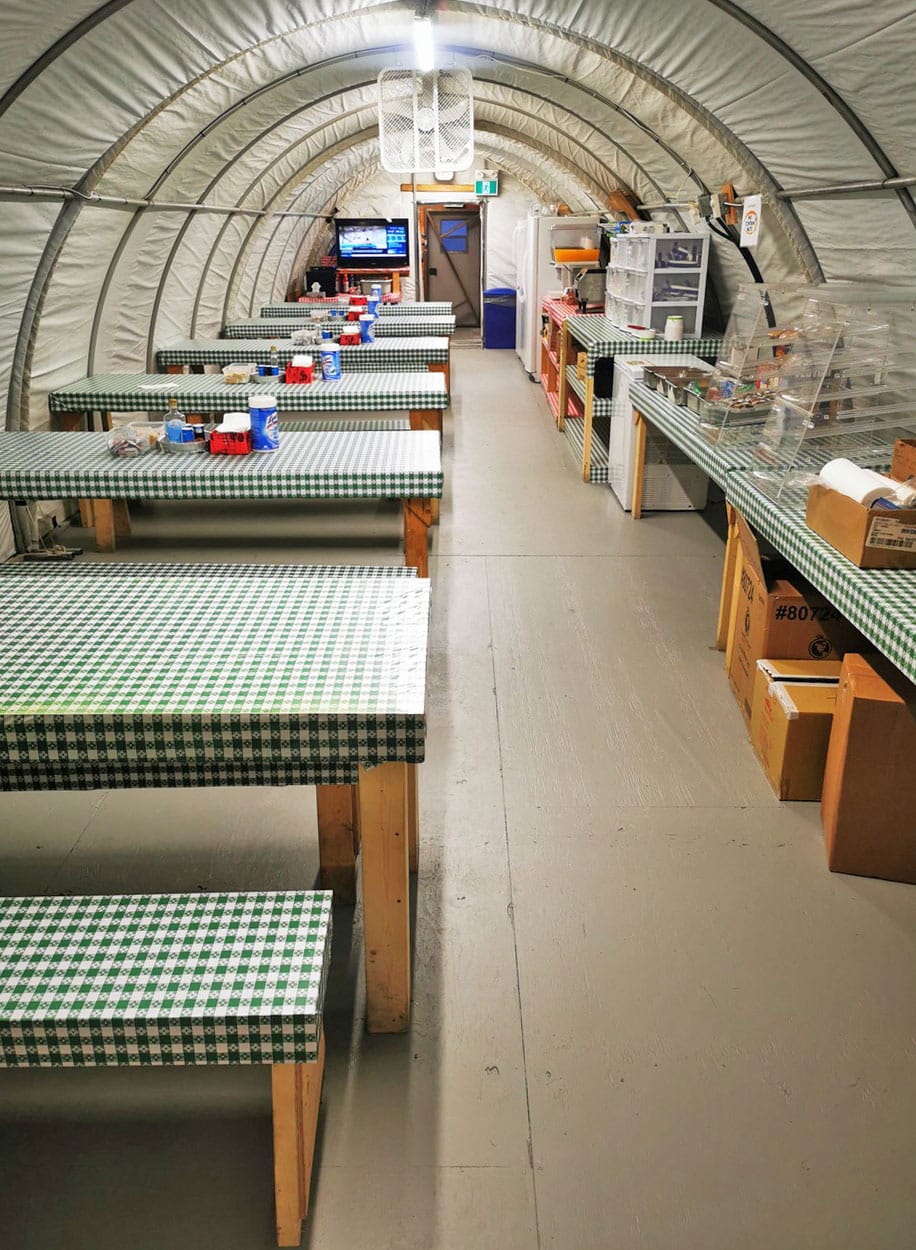 interior-of-kitchen-and-dining-facility-at-an-exploration-camp-nwt-canada-from-discovery-mining-services-using-fabric-buildings-from-alaska-structures-2 Interior of a kitchen and dining facility at an exploration camp in the Northwest Territories, Canada, supporting remote workforce operations. The structure features a pre-engineered fabric building from Alaska Structures®, providing a clean, comfortable, and climate-controlled environment for crews working in remote locations. Photo courtesy of Discovery Mining Services.