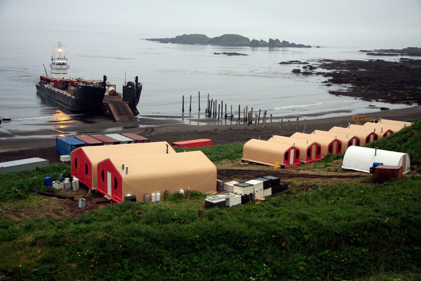 roll-on-roll-off-exploration-camp-on-tanaga-island-1 Roll-on/roll-off (RORO) mining camp deployment on Tanaga Island in the Aleutian Islands, Alaska, demonstrating flexible transport and installation of fabric buildings from Alaska Structures® in remote coastal locations.