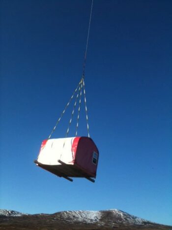 Helicopter delivering a GB Series fabric building by sling load to a fly-in camp at Pebble Creek, Bristol Bay, Alaska