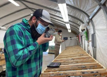 Geologists logging drill core samples inside a GB Series fabric building core logging facility
